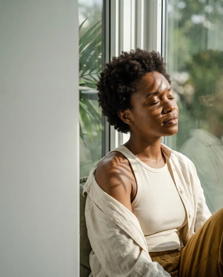 A woman enjoys a quiet moment near a window