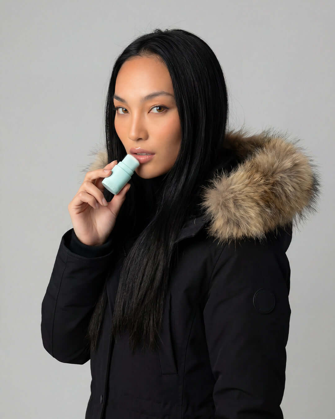 Femme appliquant le baume à lèvres rechargeable basic. cure
