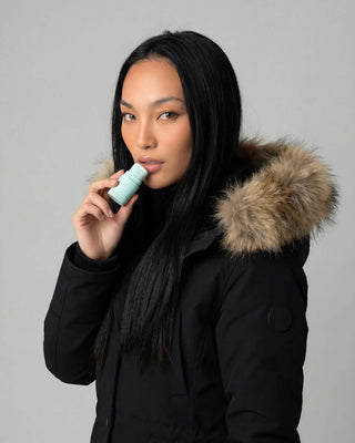 Femme appliquant le baume à lèvres rechargeable basic. cure