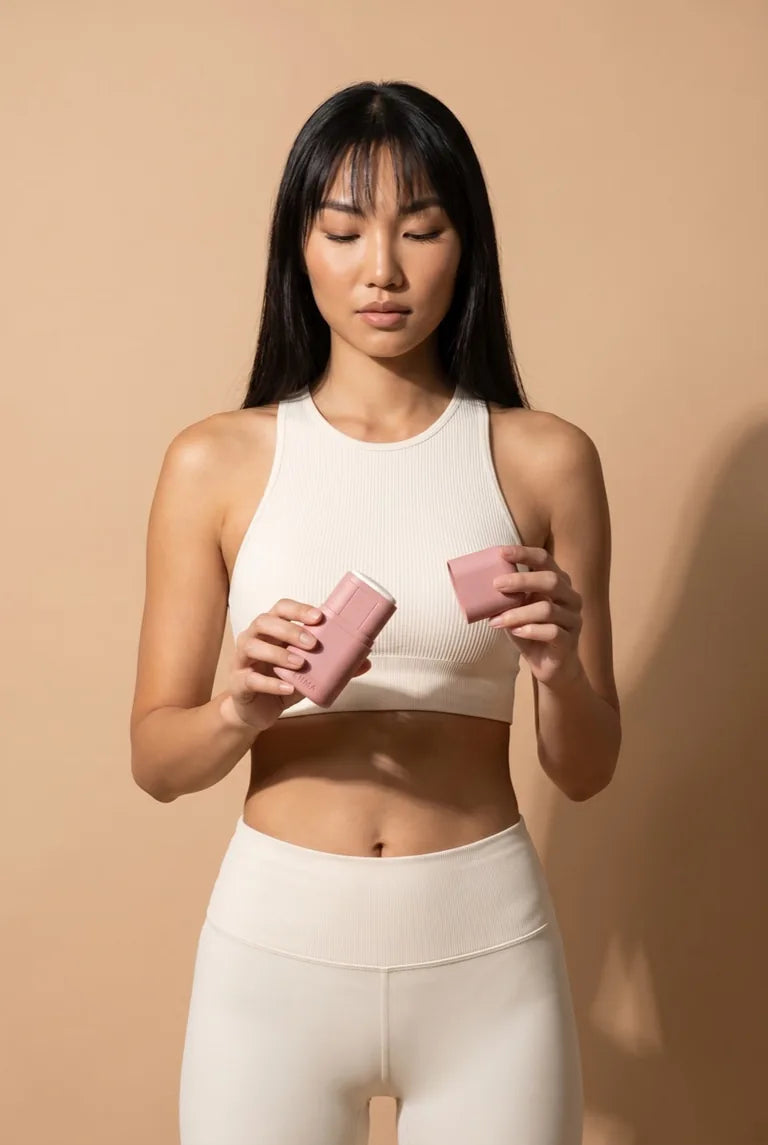 Eine Frau öffnet ein rosa nachfüllbares Deodorant